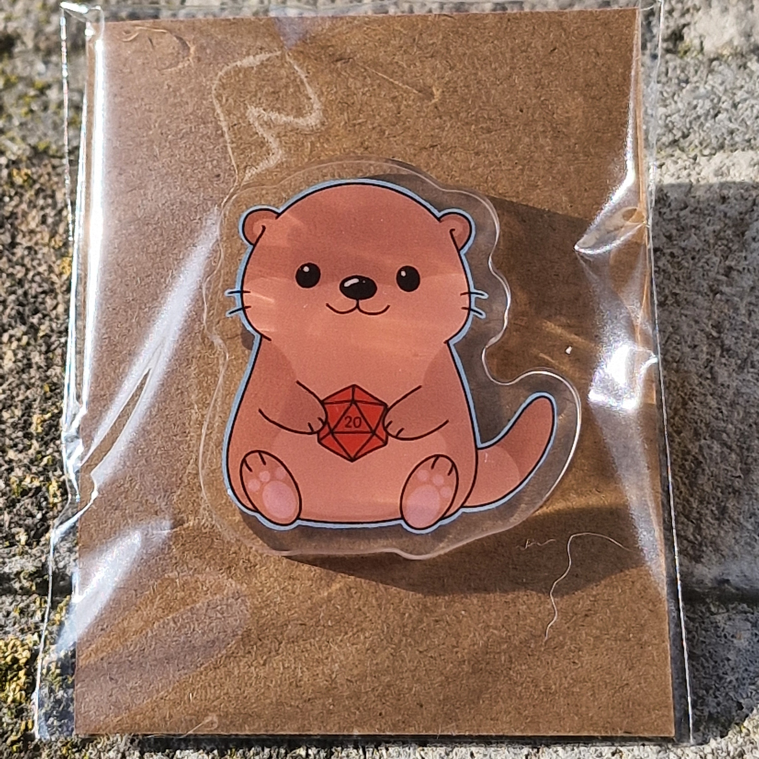 Acryl Pin – Otterly Lucky (Otter met D20)